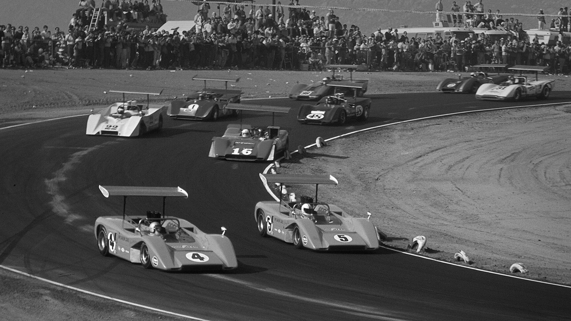 Black and white image of McLaren cars racing in a race from the Can-Am (Canadian-American Challenge Cup) series.