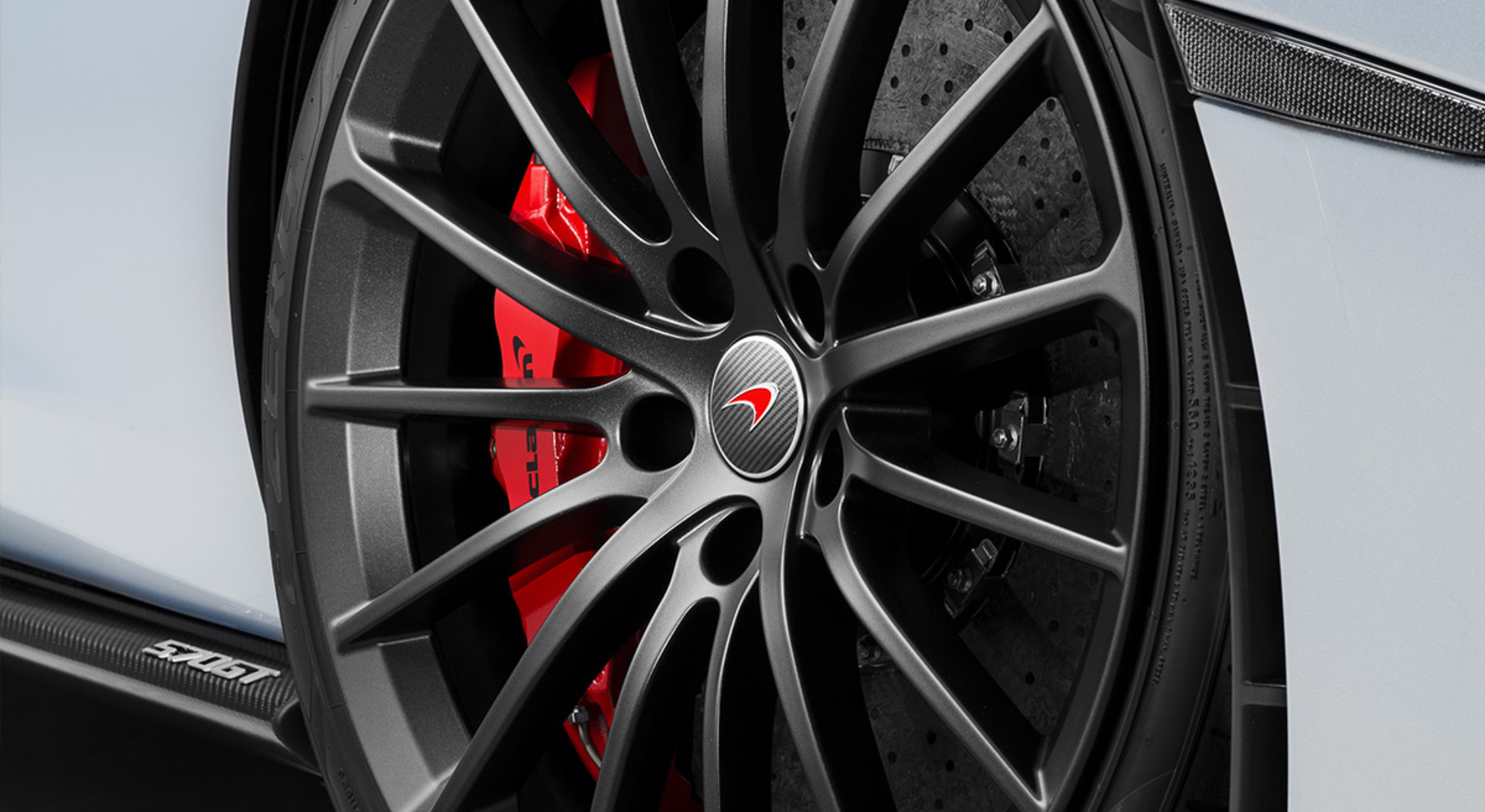 Close up detail of a McLaren 570S GT wheel with red caliper.