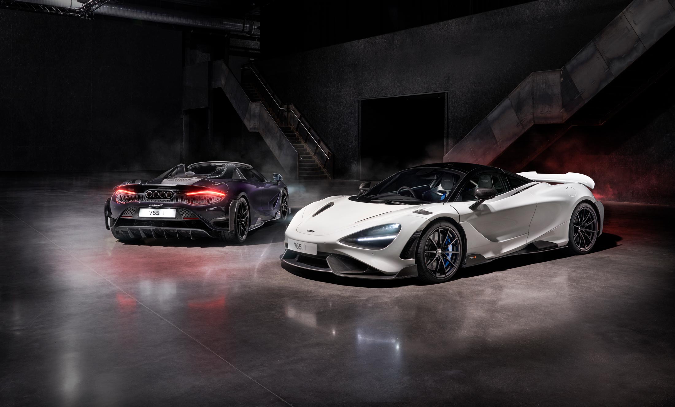 Two McLaren 765LT supercars in white and deep purple, highlighting aerodynamic design and carbon fiber details