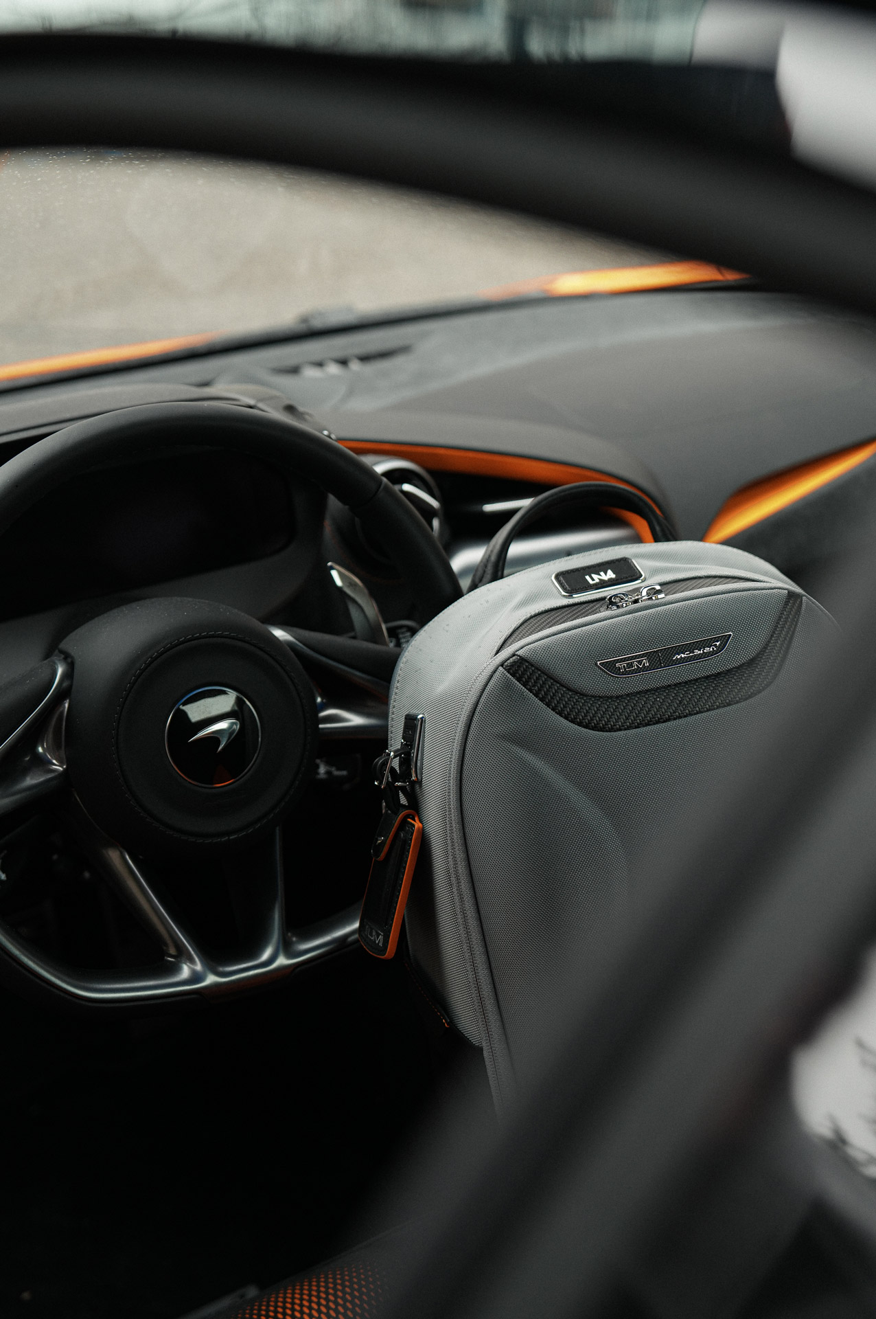TUMI T-Tech luggage on the passenger seat of a McLaren Artura, showcasing the custom fit and luxury interior with carbon fiber trim.