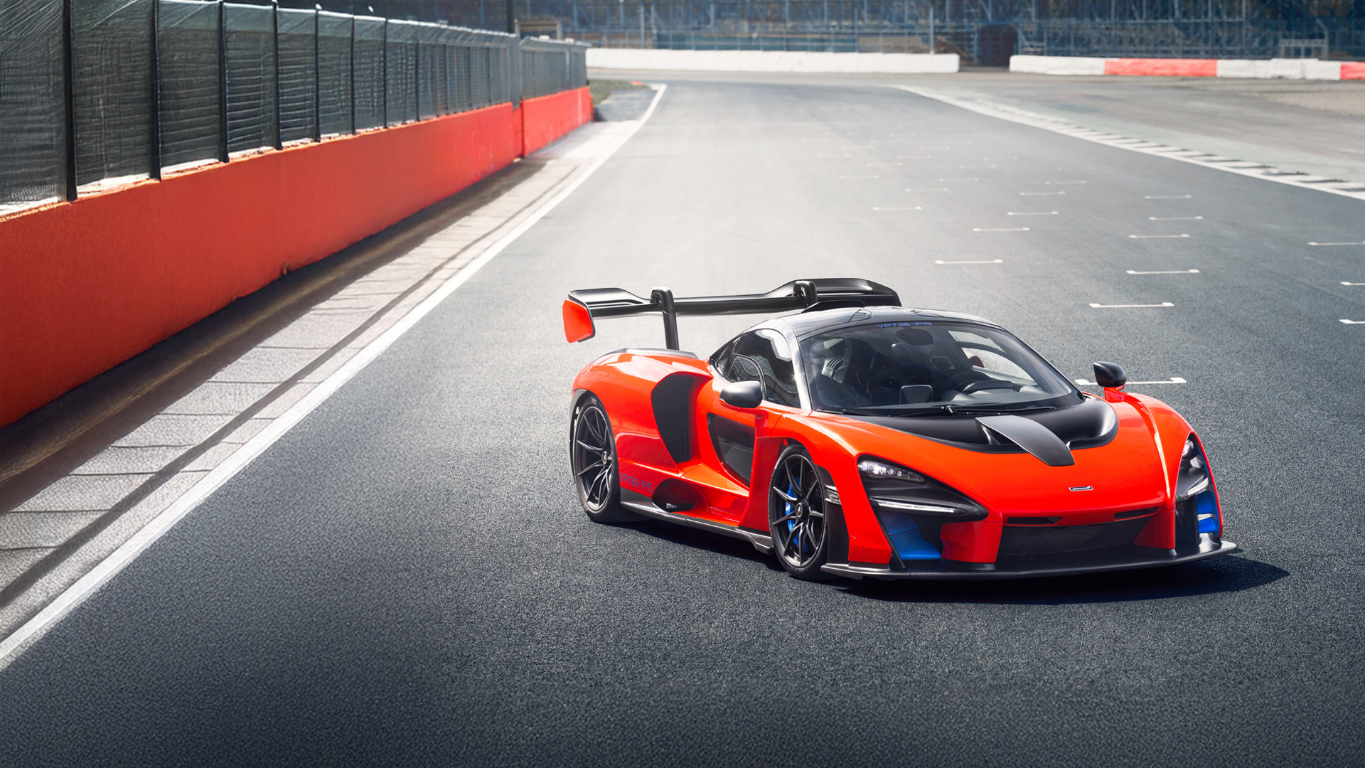 The red McLaren Senna parked across the Silverstone track start line.
