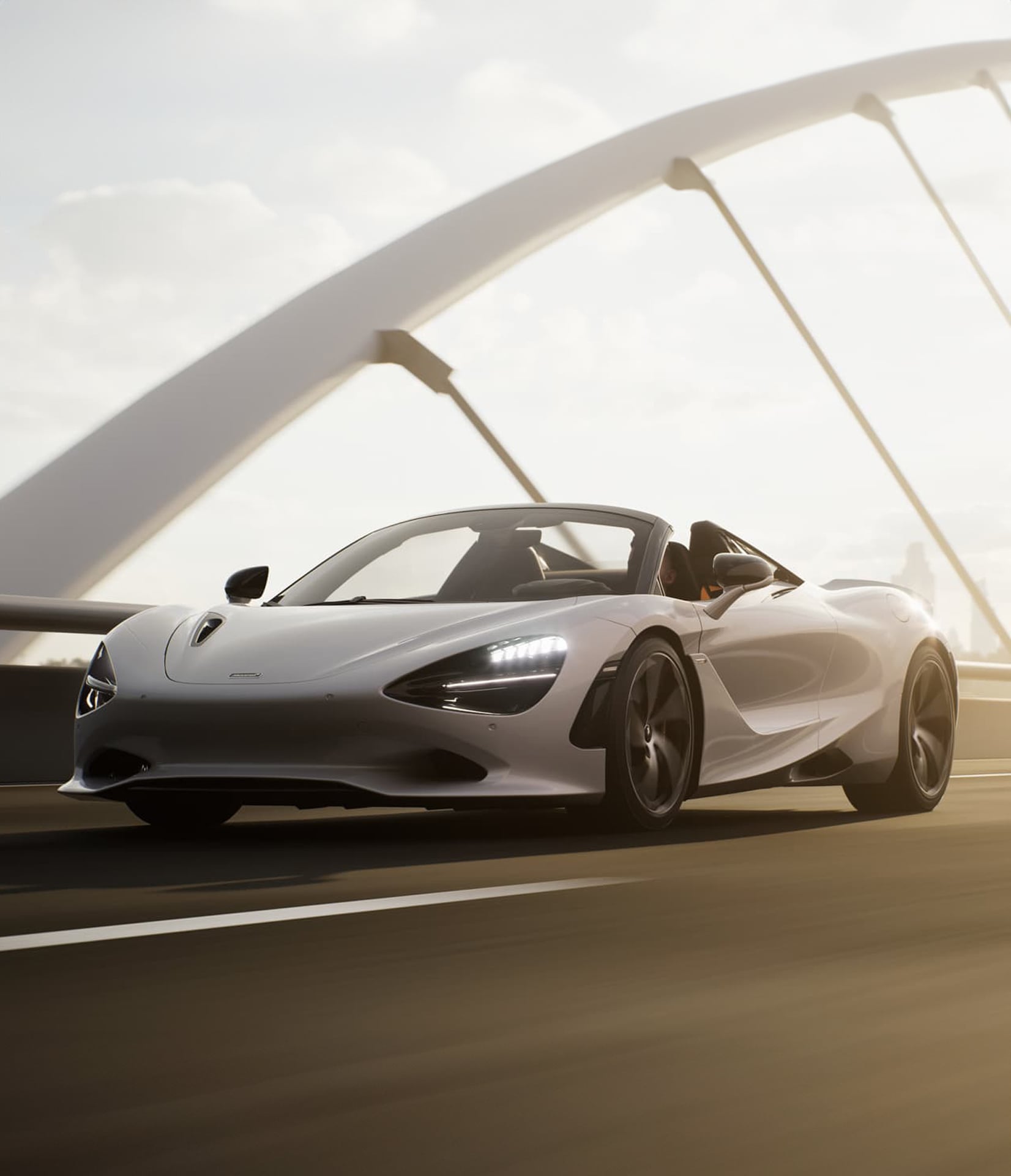 A white McLaren 750S Spider driving over a bridge in the sun.