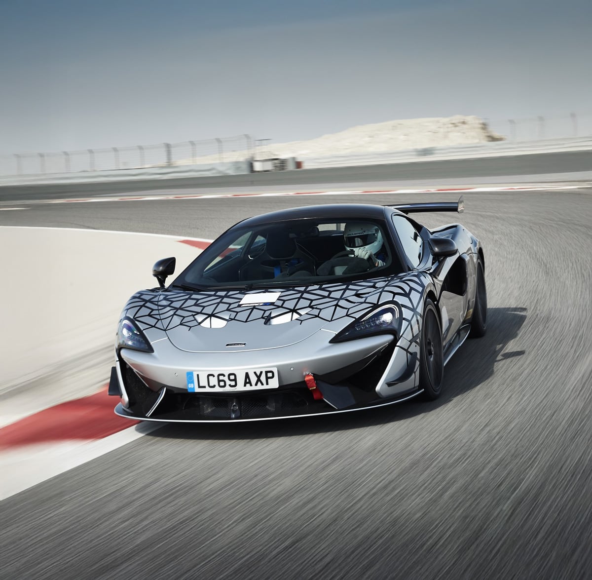 McLaren 620R driving around the bend of a race track at speed.