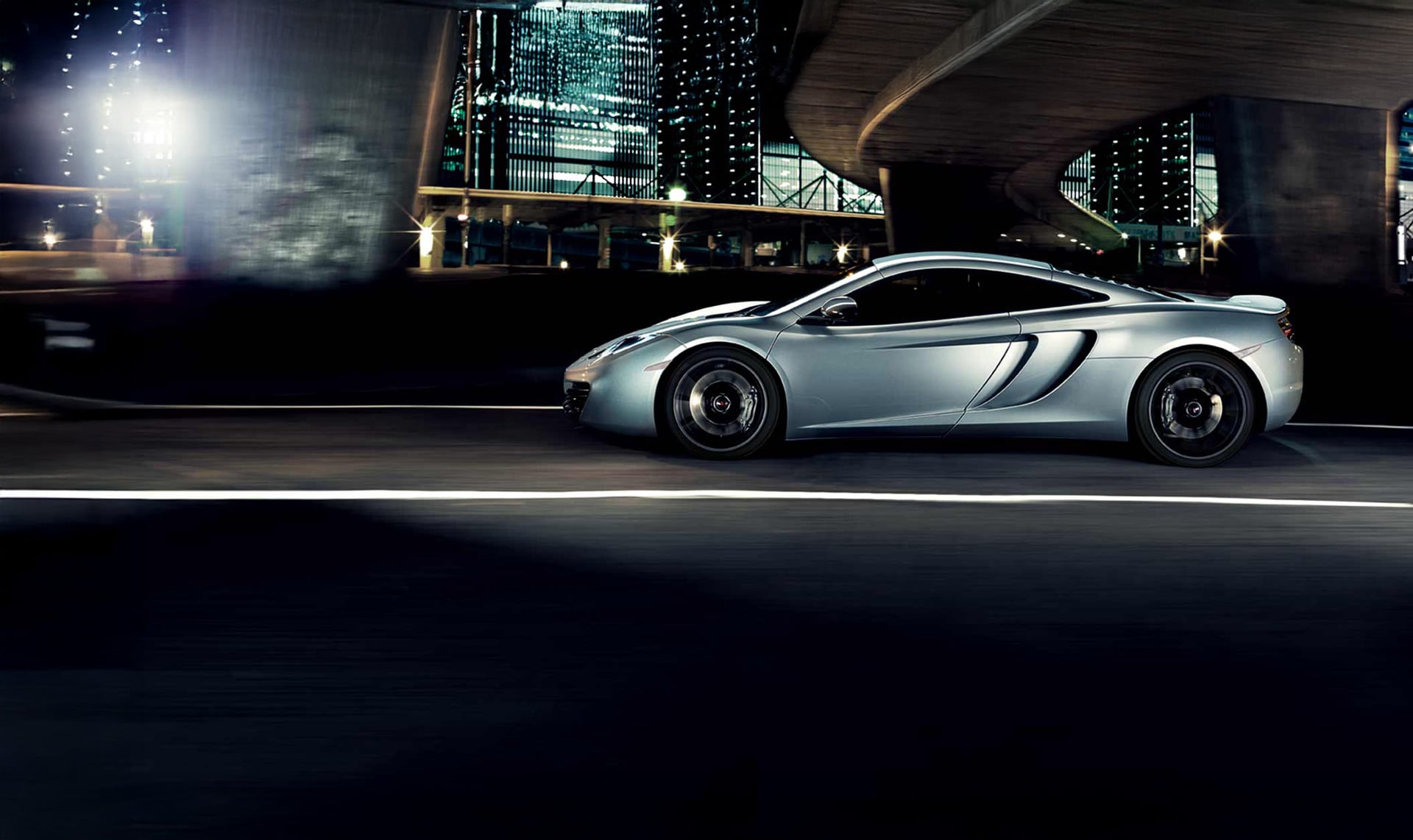 White McLaren 12C parked outside of a modern, white building.