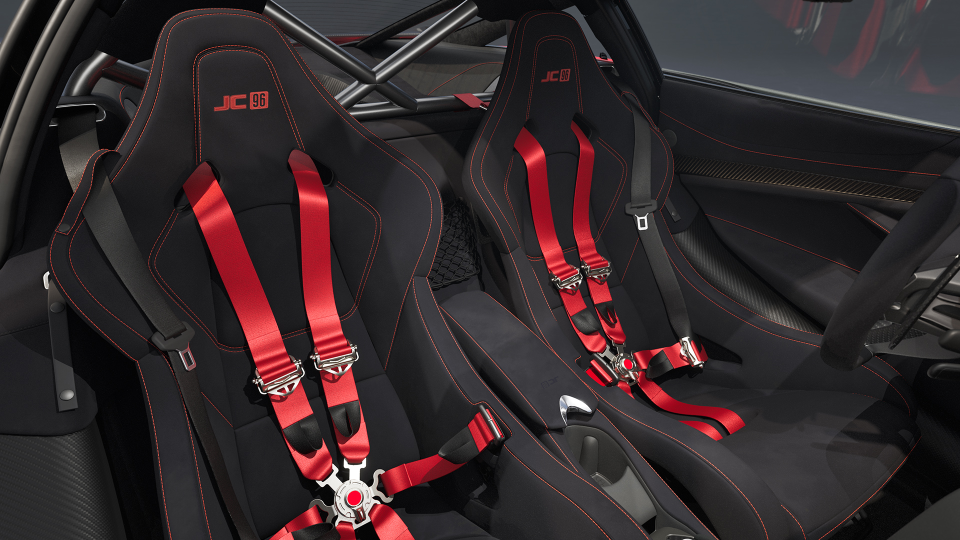 Interior view of the McLaren 750S JC96 cabin, with black Alcantara seats, red racing harnesses, and "JC 96" embroidered logos.