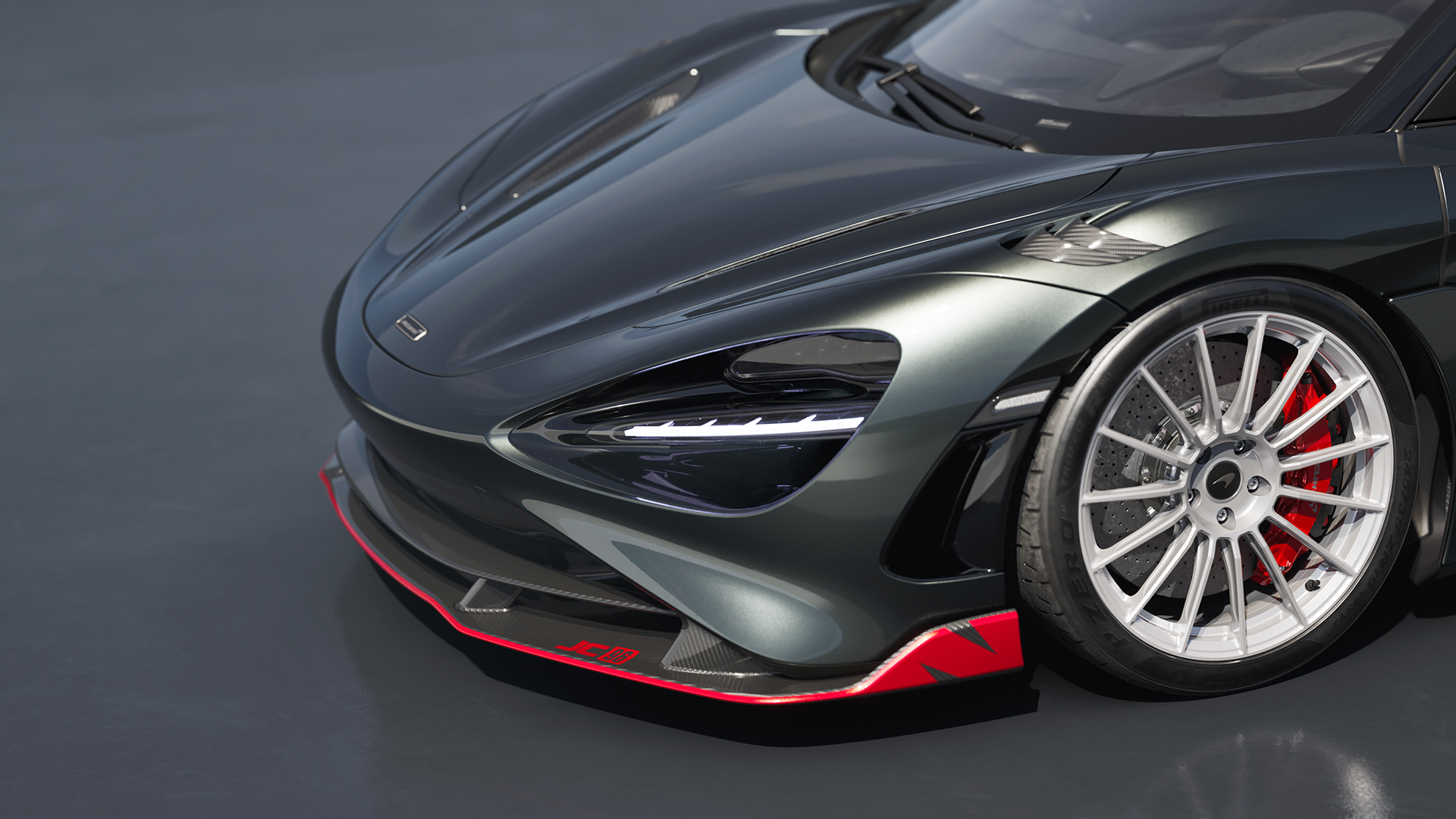 Close-up of the front wheel of the McLaren 750S JC96 Spider, highlighting its red brake calipers, silver wheels, and red aero accents.