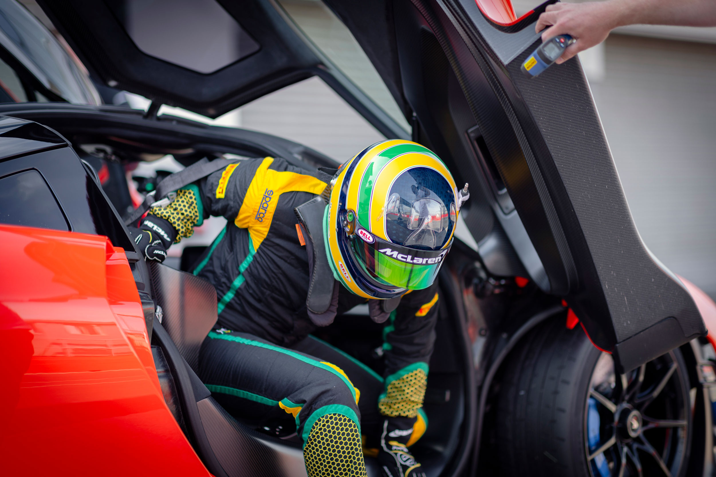 Sena Racing A racing driver wearing a helmet with Ayrton Senna's iconic livery ...