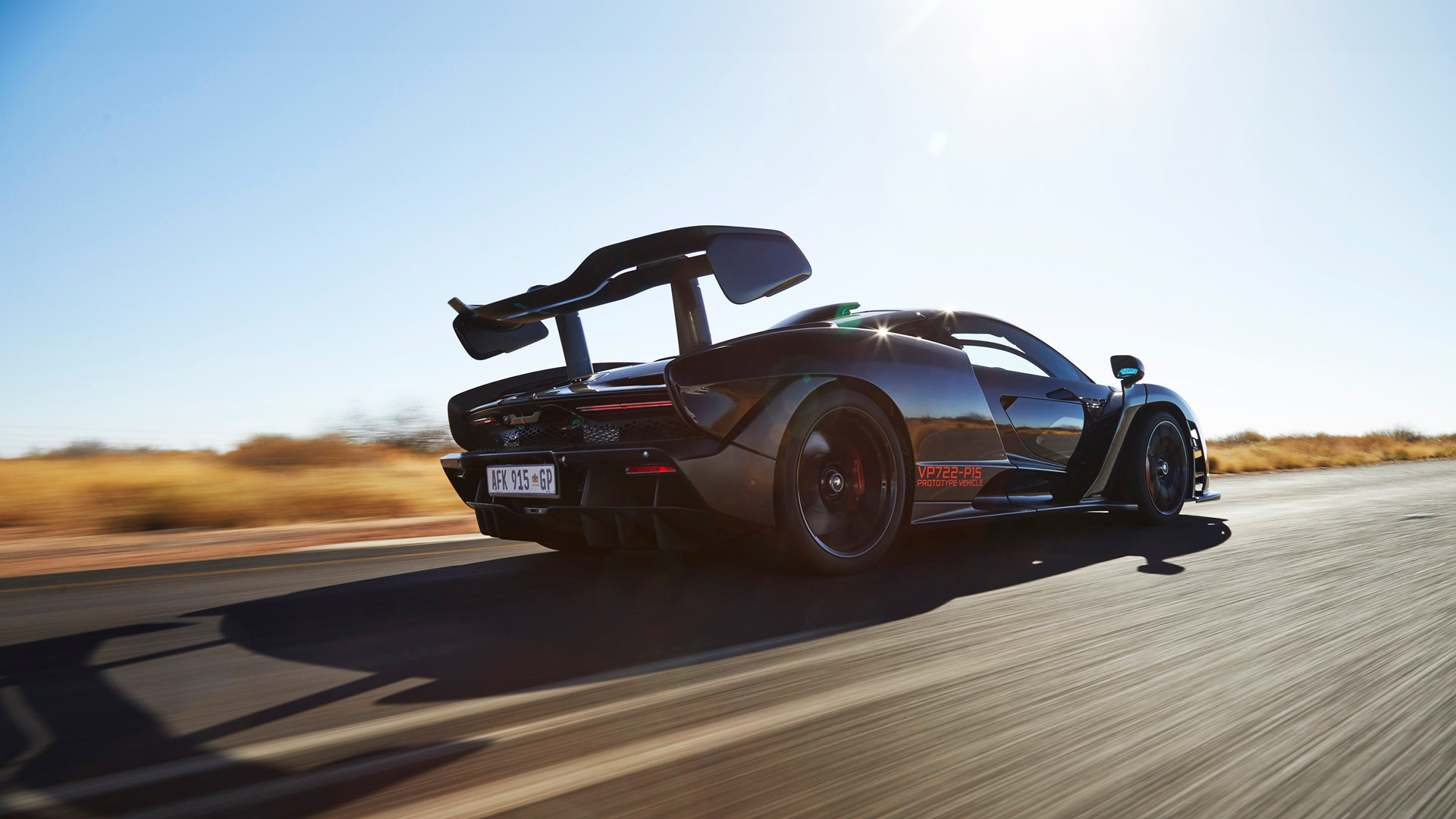 A rear-quarter view of the McLaren Senna speeding down an open road ...