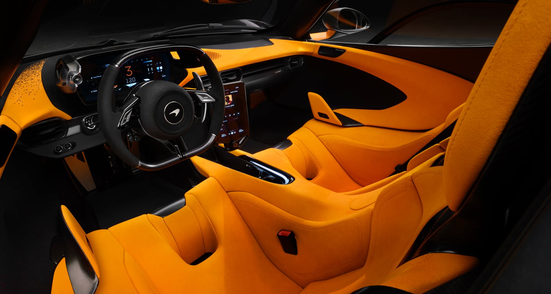 A detailed interior shot of the McLaren W1 showing bright orange bucket seats, a minimalist dashboard, and a sporty steering wheel.