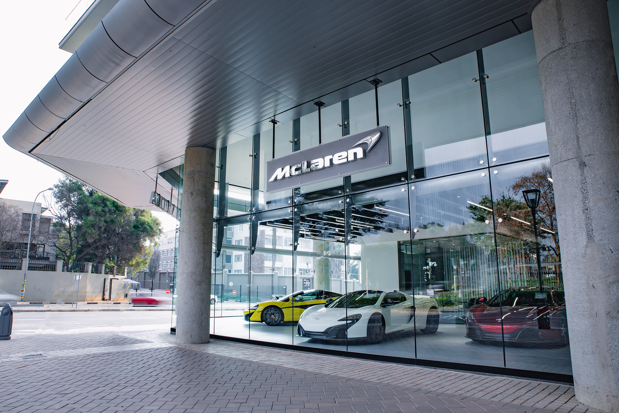 A series of McLaren cars on display in the window of the McLaren Johannesburg storefront. 