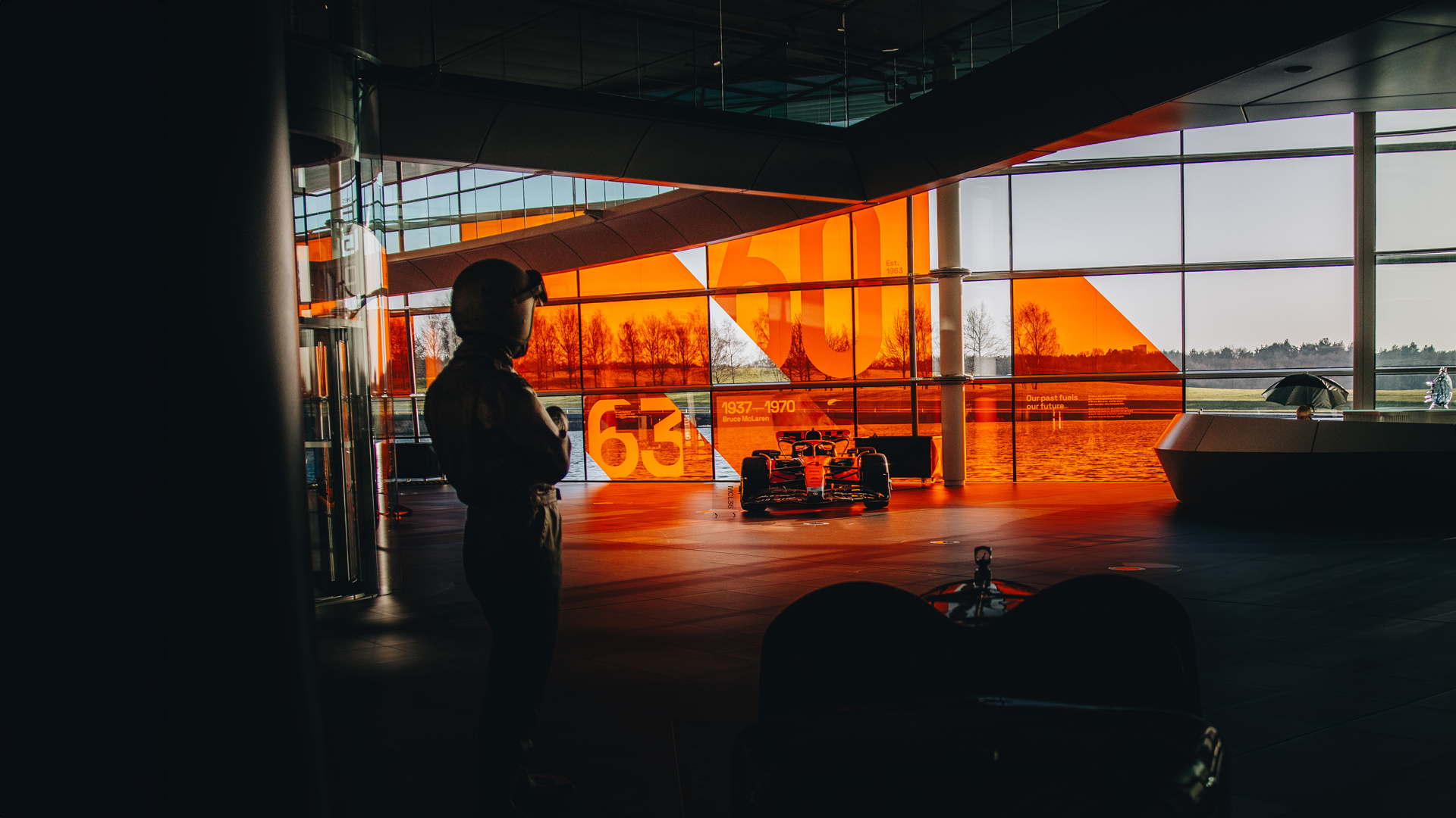 A shot of the Bruce McLaren statue surrounded by multiple McLaren F1 cars situated within the MTC.