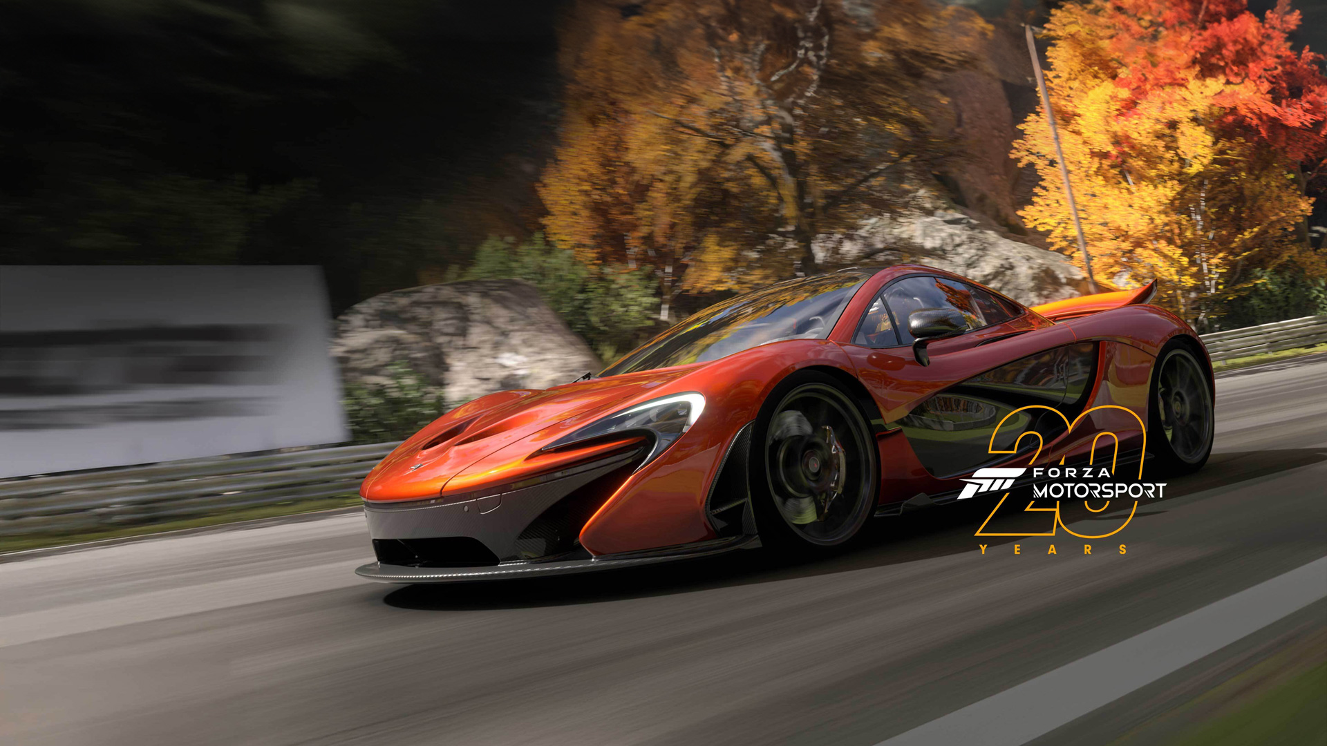 Burnt orange McLaren P1 driving down a road at speed, surround by autumn trees. A "Forza Motorsport 20 Years" logo is superimposed on the right side of the image.