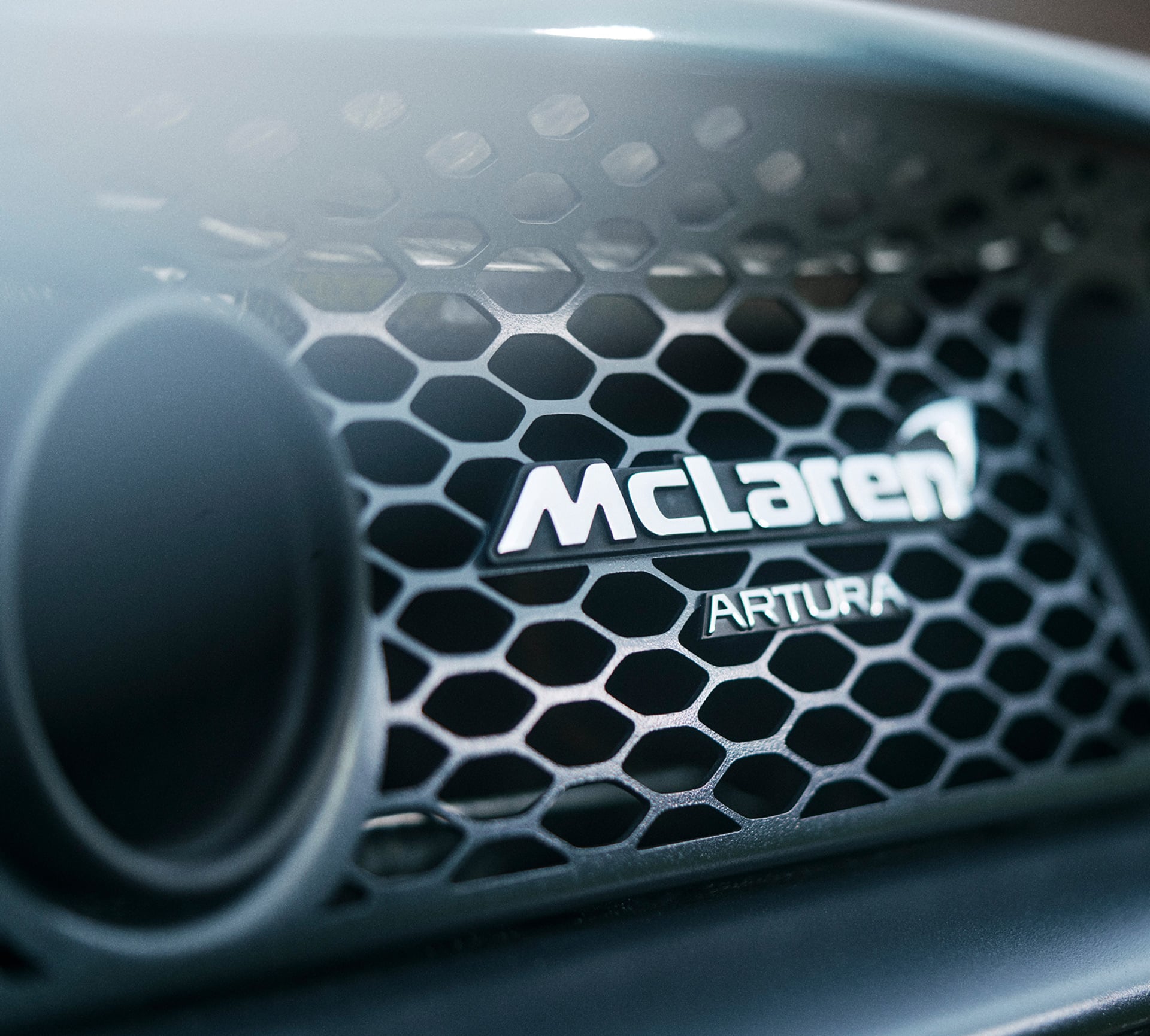 A close up view of the McLaren Artura badge on the rear grill of a McLaren Artura Spider.