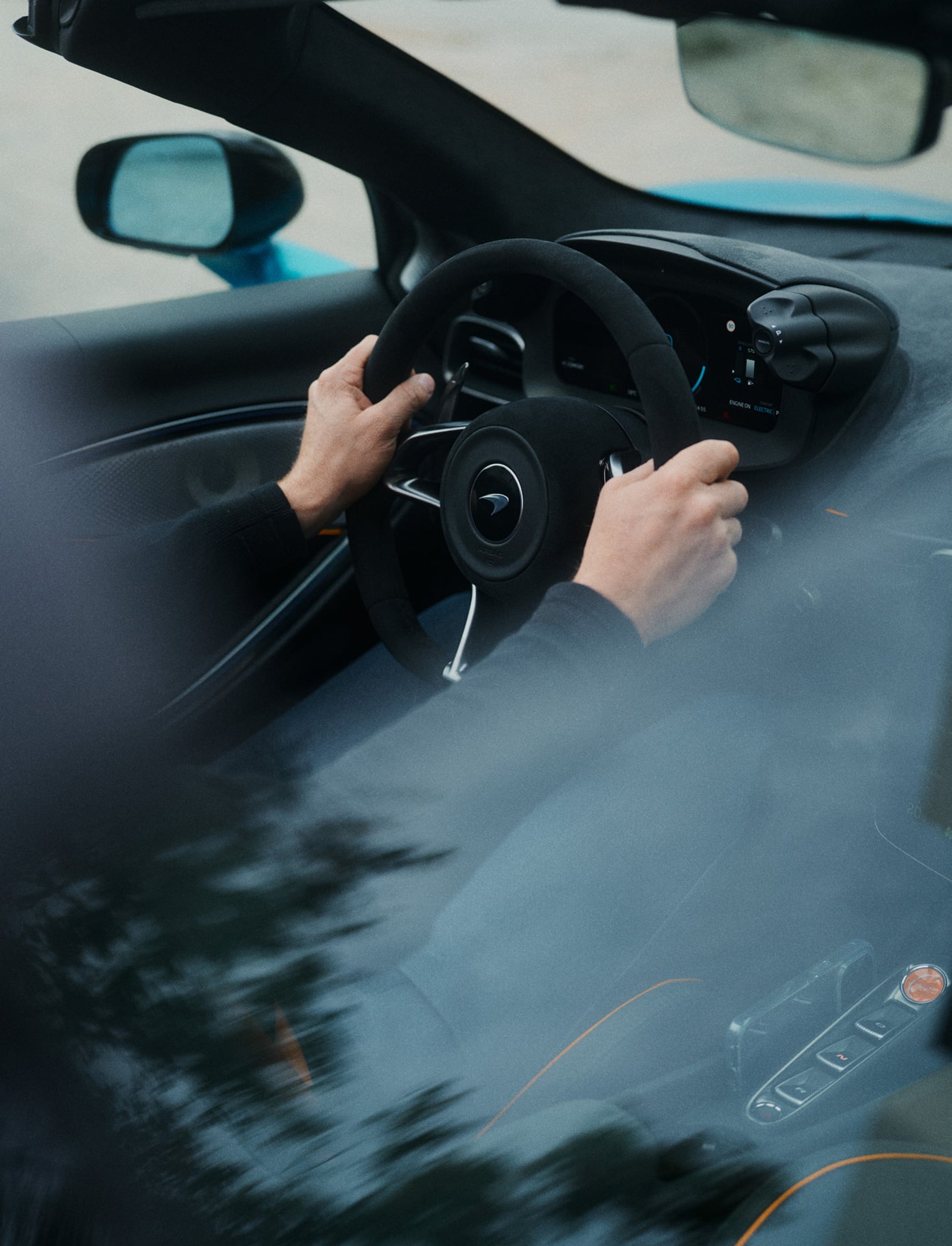 A McLaren customer holding the steering wheel of the McLaren Artura Spider.