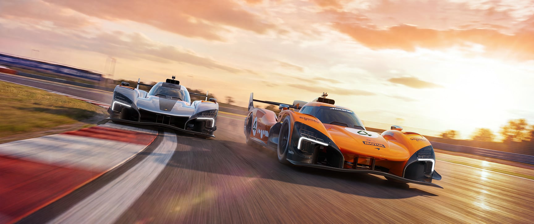 Orange MCL-HY and silver MCL-HY GTR driving on track at sunset with motion blur.