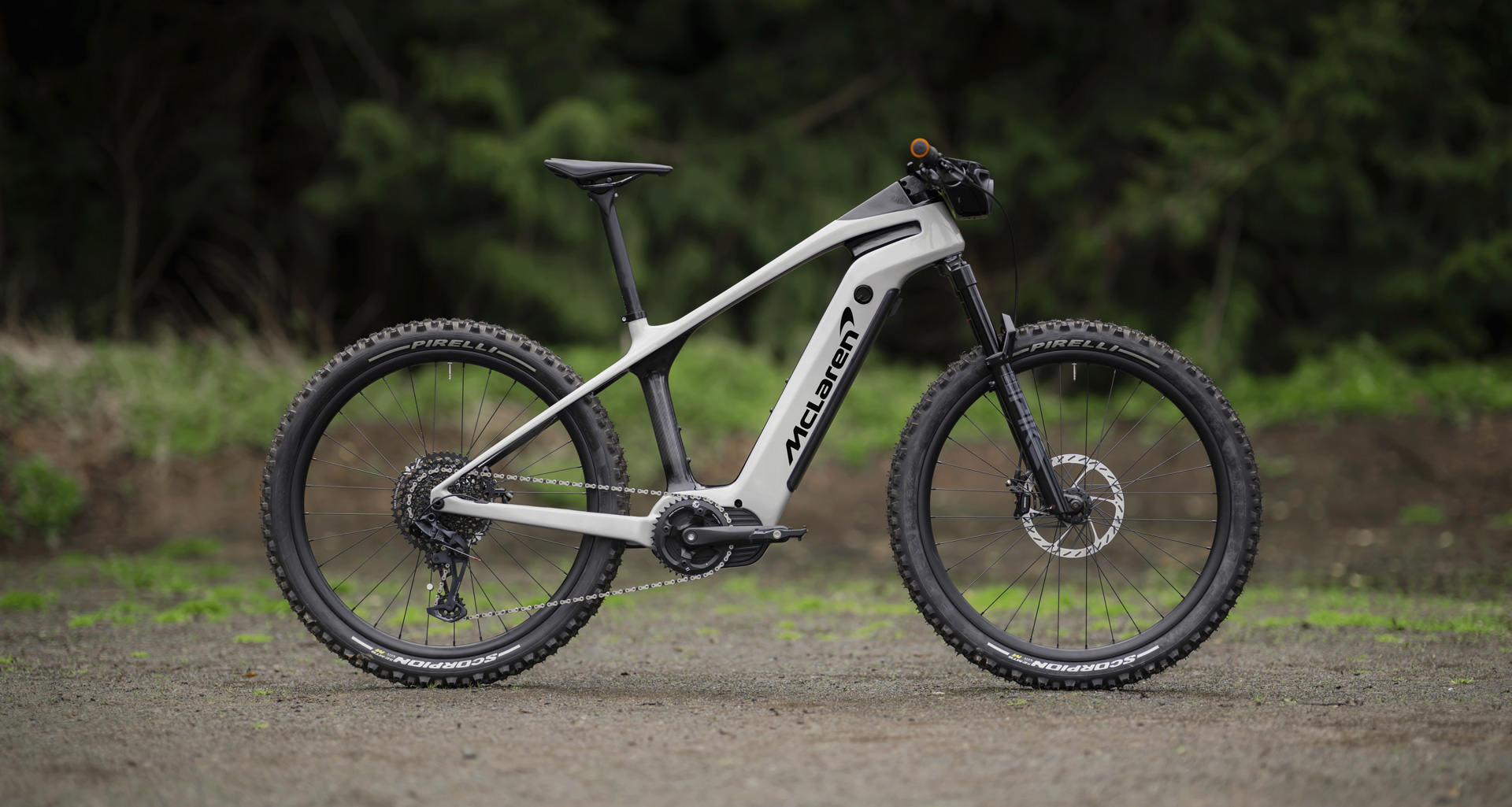 White McLaren E-bike Sport model in a forest.